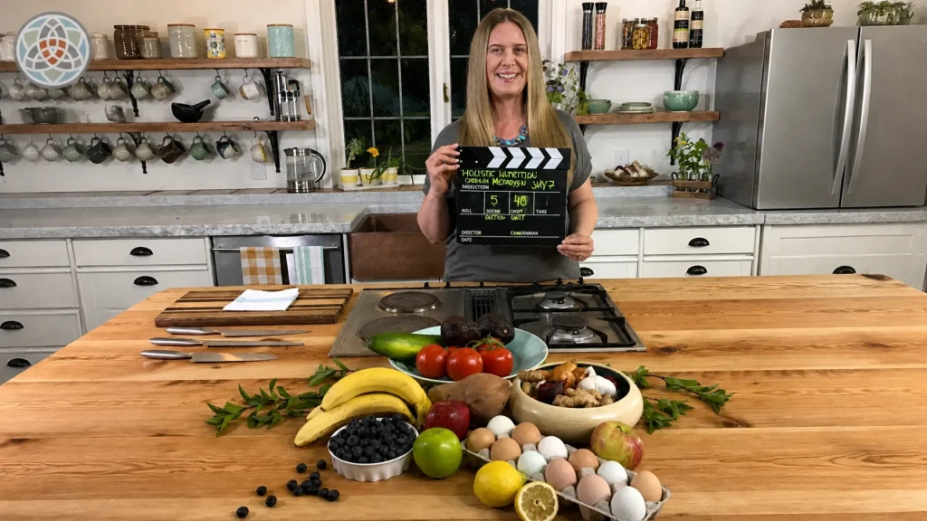 Holistic Nutritionist Cordelia McFadyen leading a cooking course in a kitchen with a variety of healing foods in front of her ready to be prepared into healthy meals.
